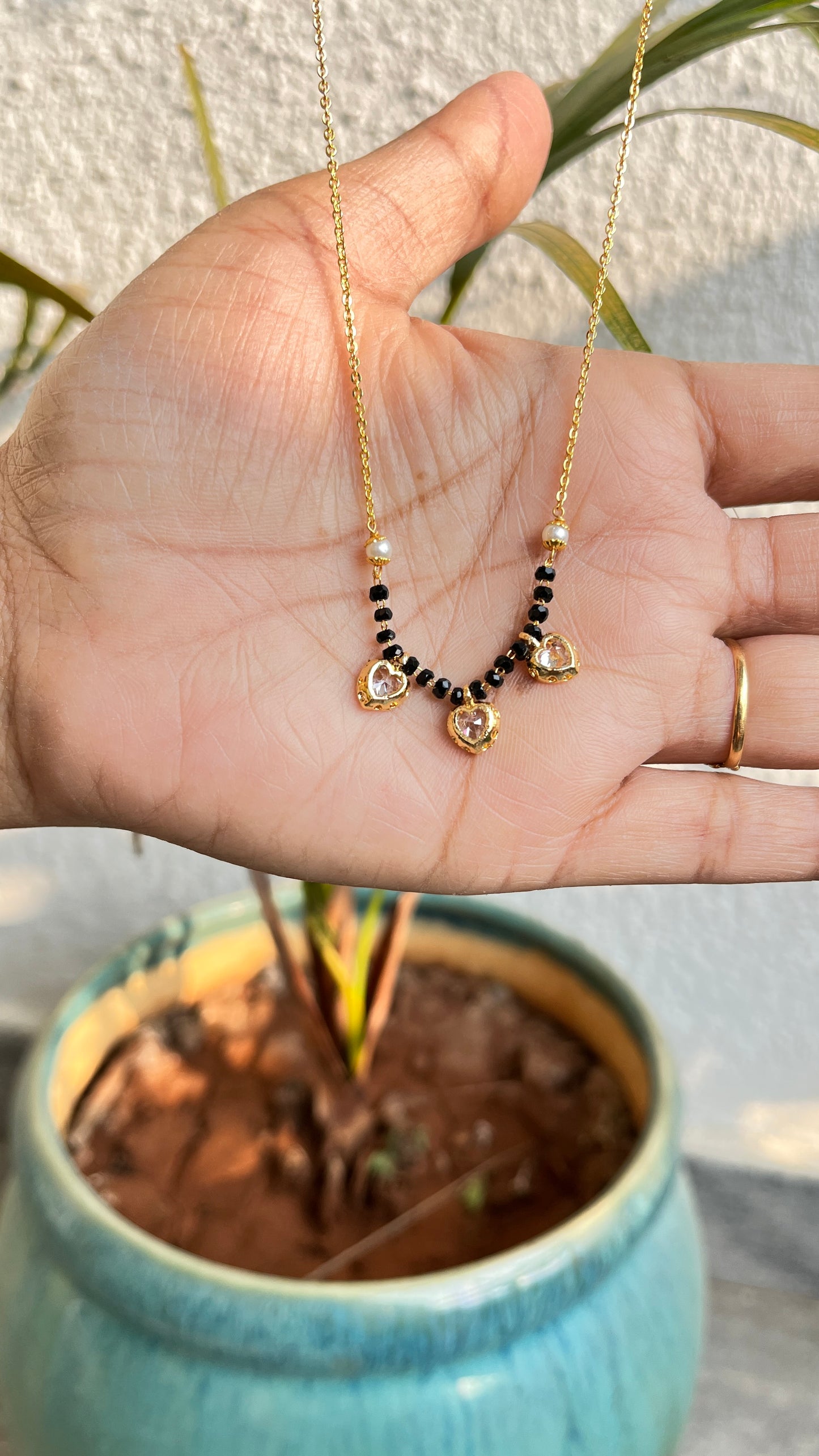 Menka Short Mangalsutra with three little hearts .
