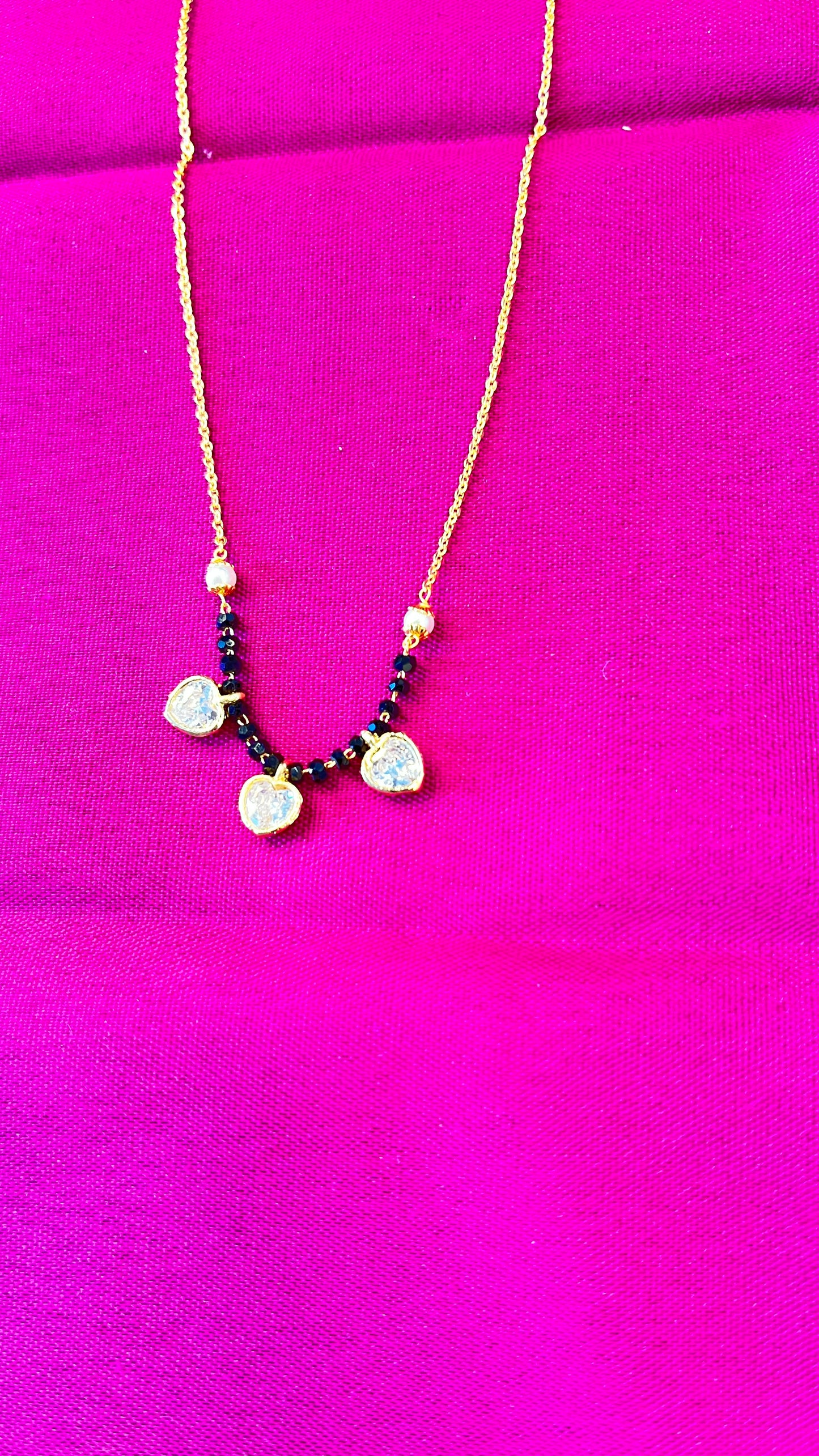 Menka Short Mangalsutra with three little hearts .