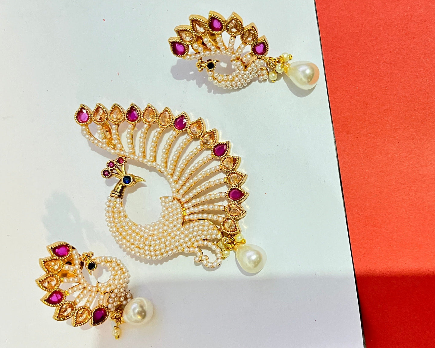 A multicolor peacock pendant with earings and a mala